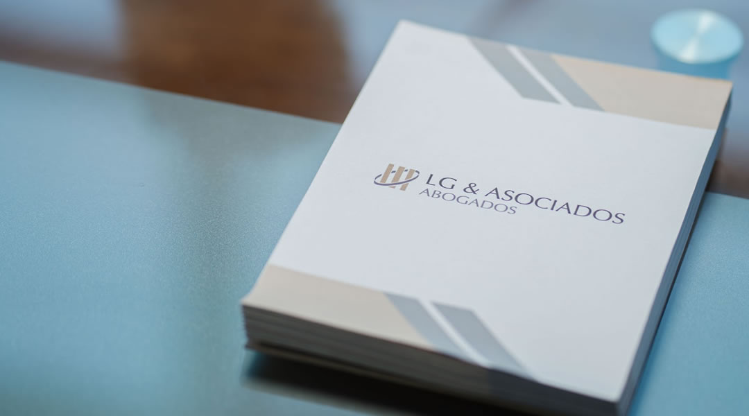 Carpetas institucionales de LG & Asociados sobre la mesa de reuniones